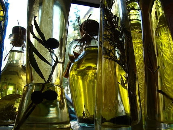 Bottles of various herbs and flowers being defused in oil.