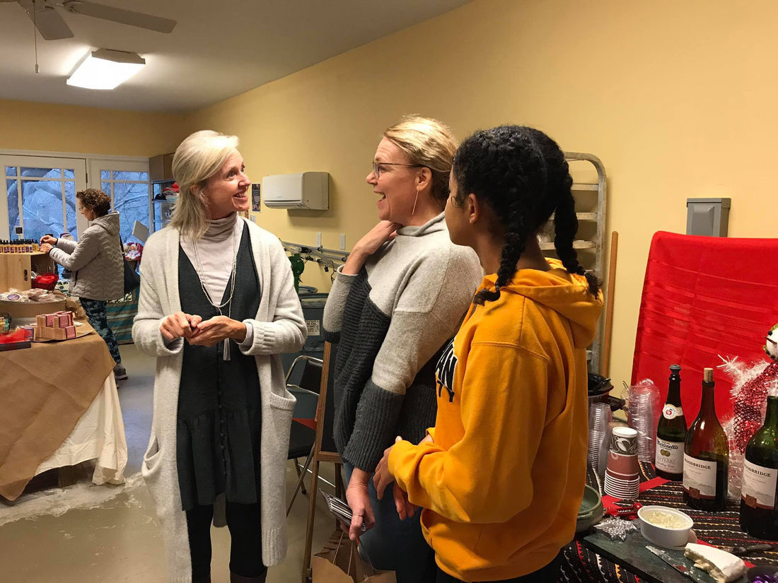 Women small business owners discussing the holiday's shopping at a local event.
