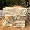 Three swirled  grapefruit soap bars by Mood indigo on a wooden surface with a natural background