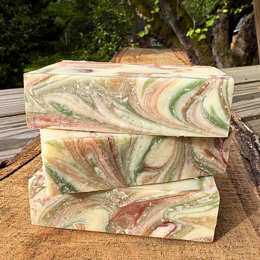Three swirled  grapefruit soap bars by Mood indigo on a wooden surface with a natural background