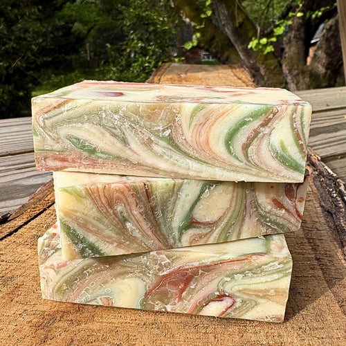 Three swirled  grapefruit soap bars by Mood indigo on a wooden surface with a natural background