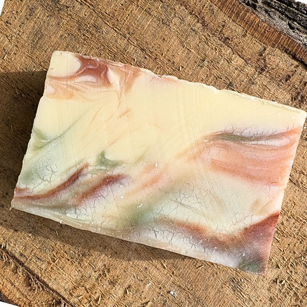 Bar of natural grapefruit soap with a marbled design on a wooden surface