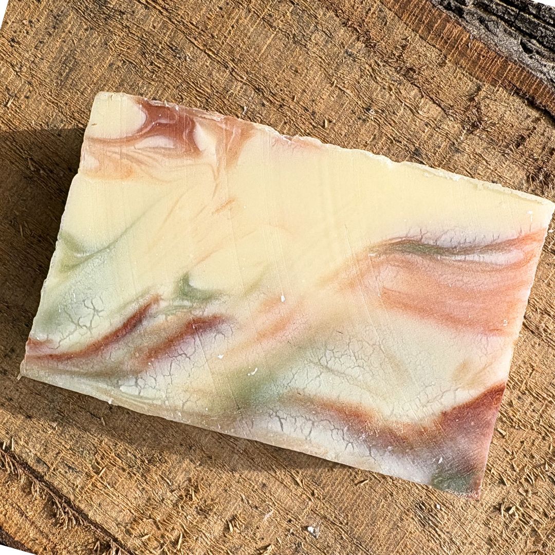 Bar of natural grapefruit soap with a marbled design on a wooden surface