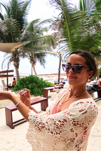 Vanilla perfume being applied in a roll on by a beautiful woman on a tropical beach