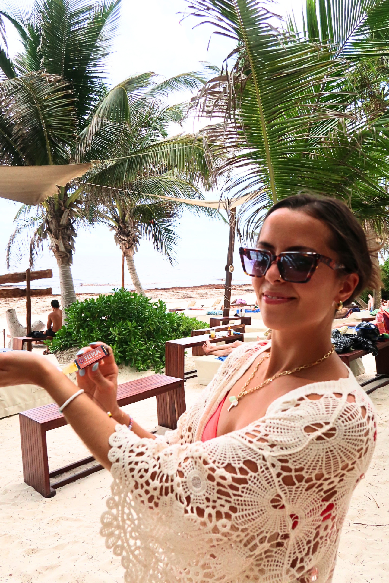 Vanilla perfume being applied in a roll on by a beautiful woman on a tropical beach