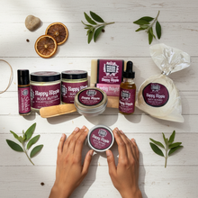 Overhead flat lay Patchouli Bliss Gift Set Happy Hippie Collection complete spa set with body butter oil scrub soaps bath bomb roll-on perfume hand balm wooden soap dish bamboo scoop