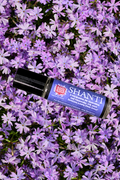 SHANTI Lavender essential oil roll on perfume from Mood Indigo over a field of pink flowers