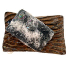 Limited edition activated charcoal and tulsi black bar soap lathering on a handmade ceramic soap dish, crafted by Mood Indigo Living in North Carolina