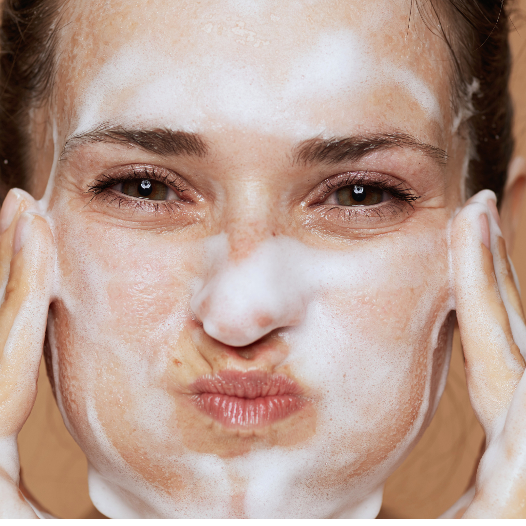 Woman washing her face with Rose Face soap by mood Indigo