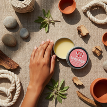 Overhead flat lay of EARTHLY DELIGHT Hand Balm with sandalwood rosewood scent, Indian woman's hands, earthy botanicals, terracotta accents, bohemian natural skincare aesthetic