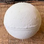 White Patchouli bath bomb on a wooden surface. Scented with patchouli essential oils and sweet orange, handmade in NC by Mood Indigo