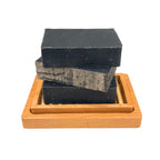 Charcoal detox soap on a wooden soap dish
